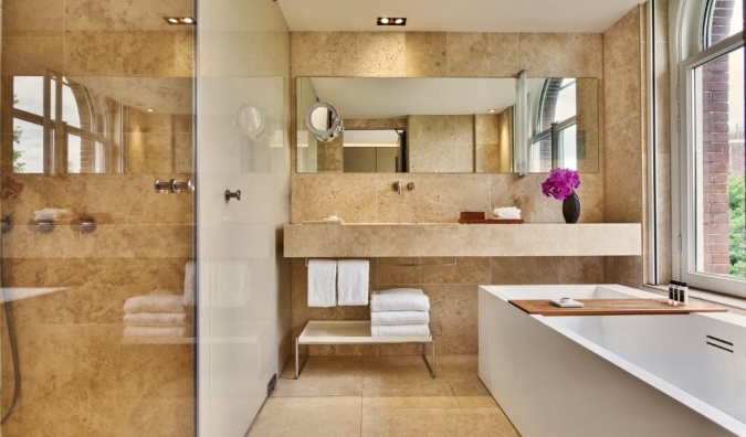 Um banheiro luxuoso com um banheiro profundo para voar no Conservatorium Hotel em Amsterdã, na Holanda