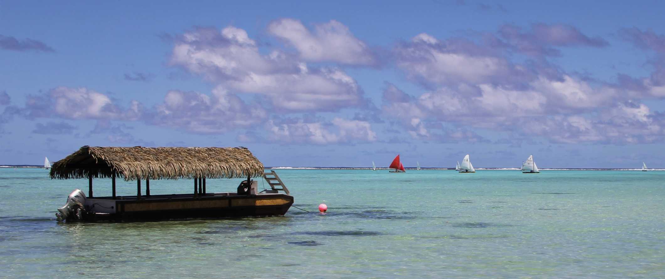 Barco de palha estacionado nas águas límpidas das Ilhas Cook