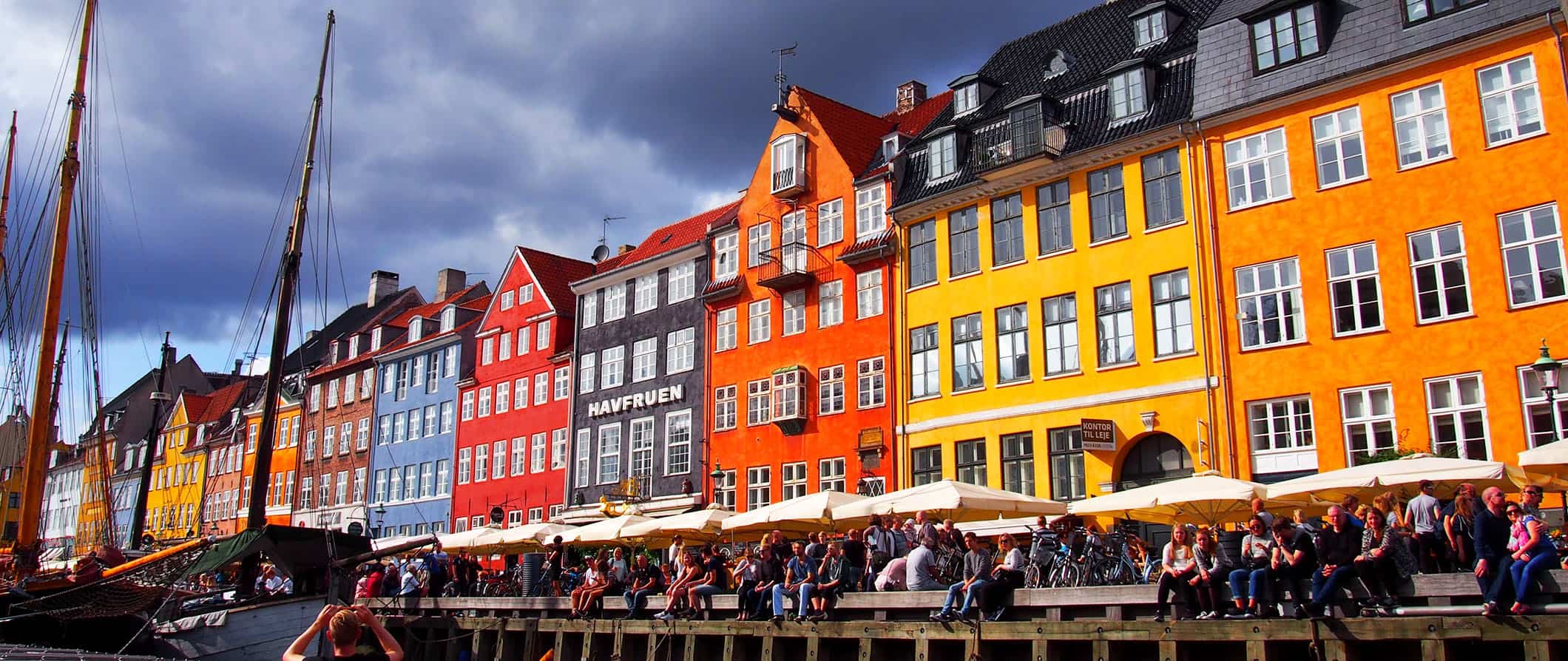 Edifícios mult i-coloridos ao longo de um dos muitos canais em Copenhague, Dinamarca