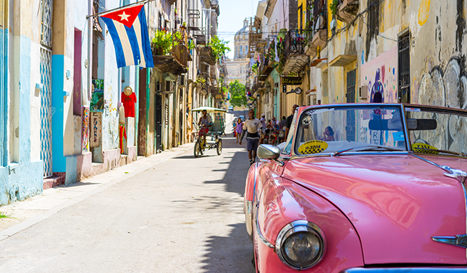 Carro rosa clássico em Cuba em uma rua movimentada