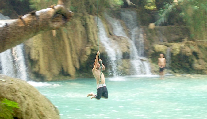 Dan Slater balança em uma corda na água na Ásia