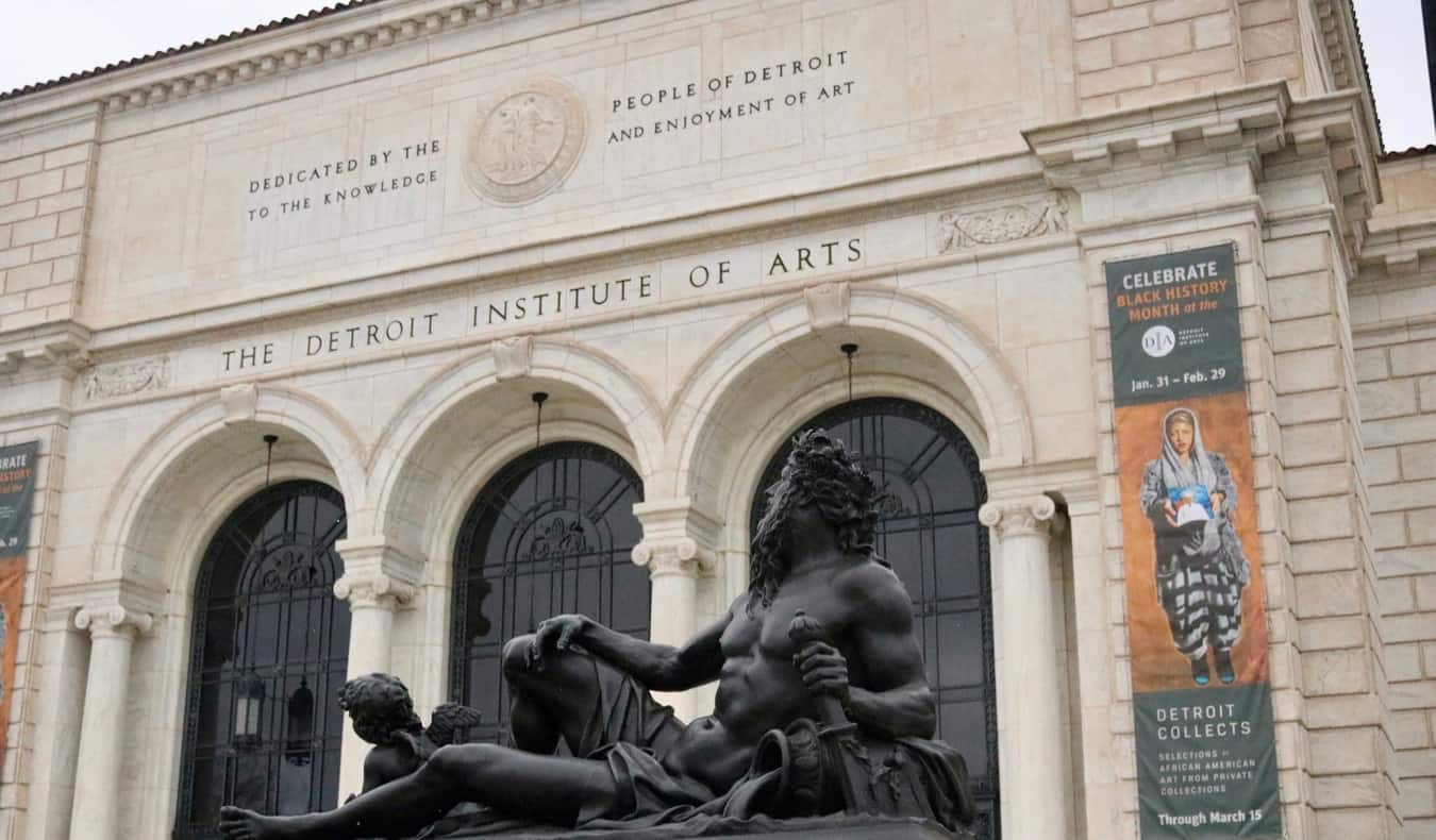 Exterior histórico do Instituto de Artes da Fighting com uma estátua escura na vanguarda