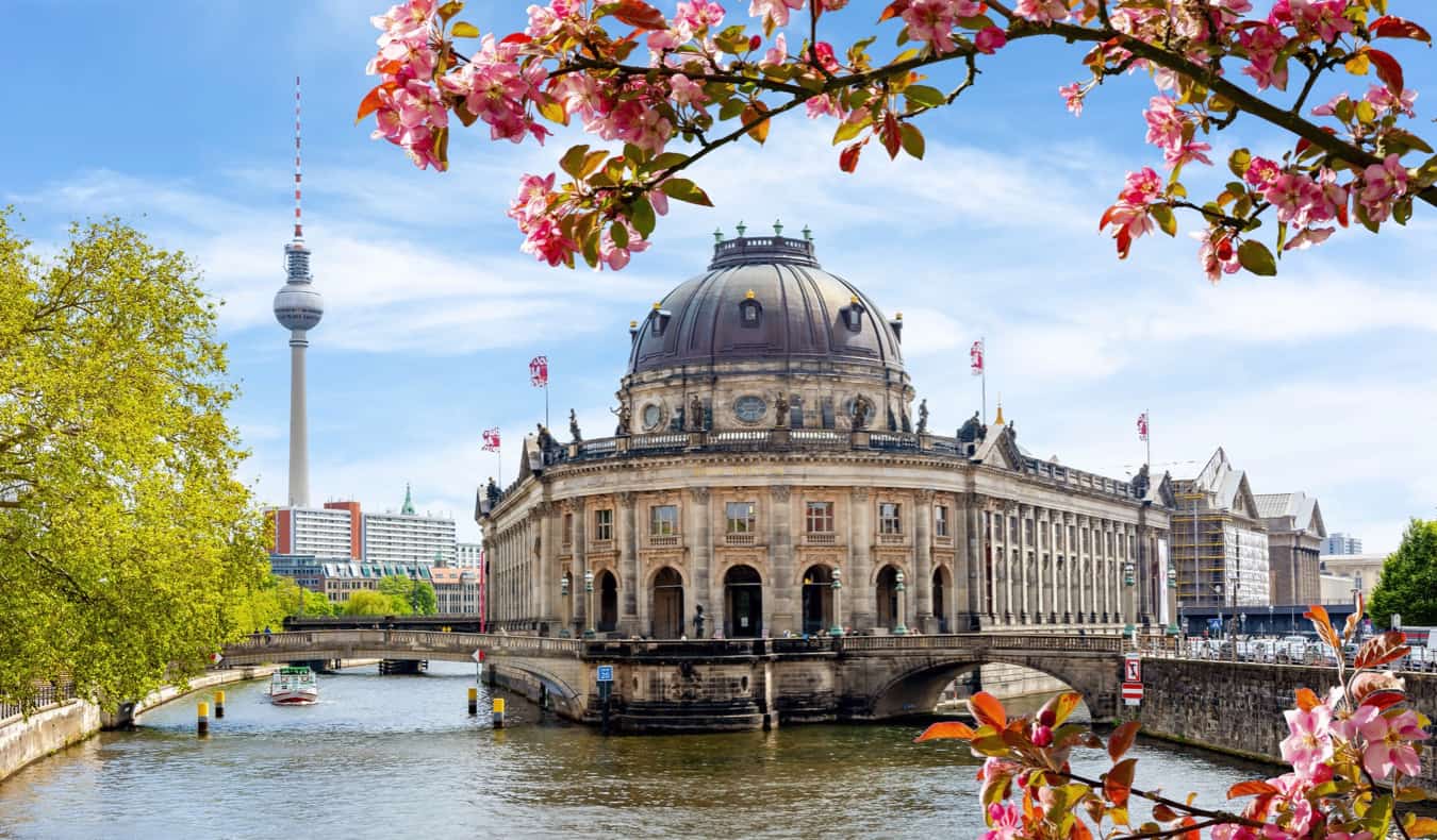 Edifícios históricos ao longo da água em Berlim, Alemanha, com a Torre de Televisão de Berlim em segundo plano