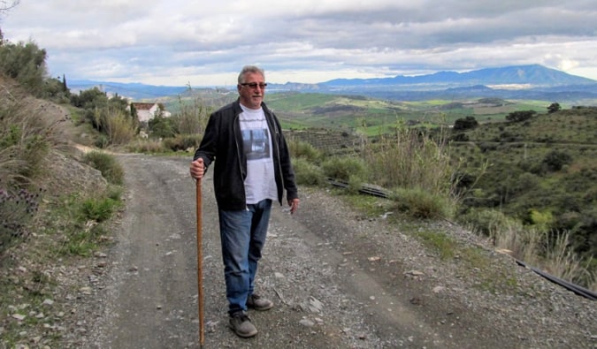 Viajante aposentado segue uma estrada vazia na Europa