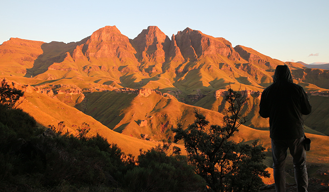 Montanhas de Drakensberg entrando em distância durante o pôr do sol na África do Sul