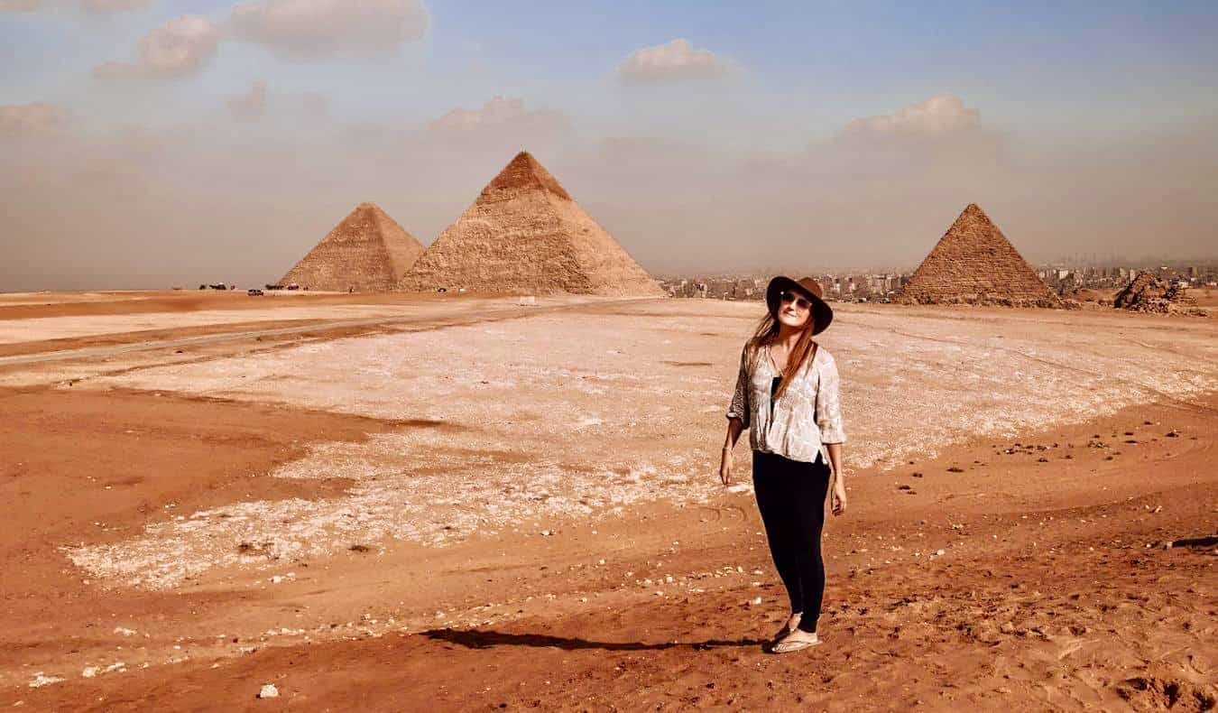 Monica, um viajante solitário, posa perto das pirâmides no Egito