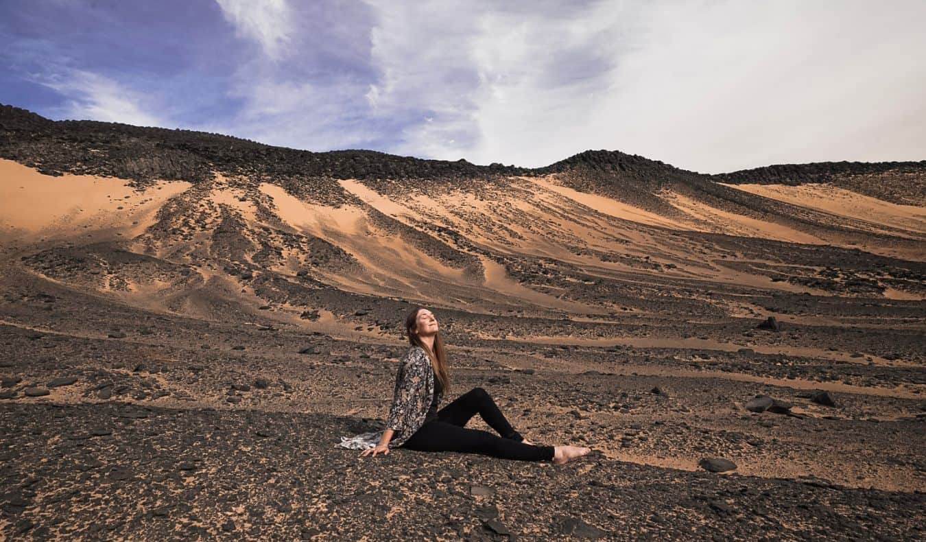 Monica, um viajante solitário, fica no deserto no Egito e posa para uma foto