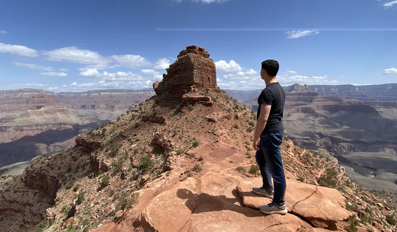 O Nomad Matt sozinho posa perto de incríveis formações rochosas enquanto visitava o Grand Canyon