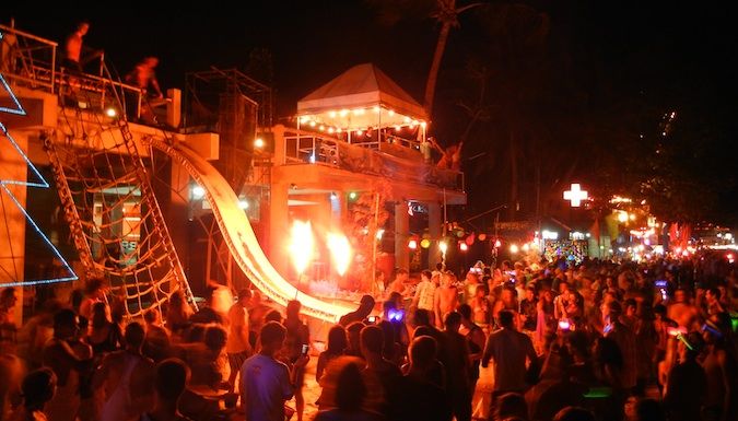 Grande multidão à noite em festa de lua cheia na praia de Haat Rin, na Tailândia