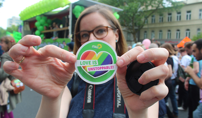 Uma menina segura um adesivo com as palavras O amor LGBT é imparável em um evento em Berlim, na Europa