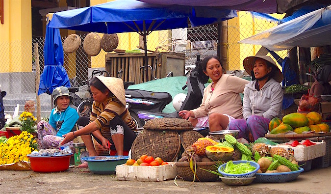 Um grupo de mulheres locais no balcão de mercado no sudeste da Ásia