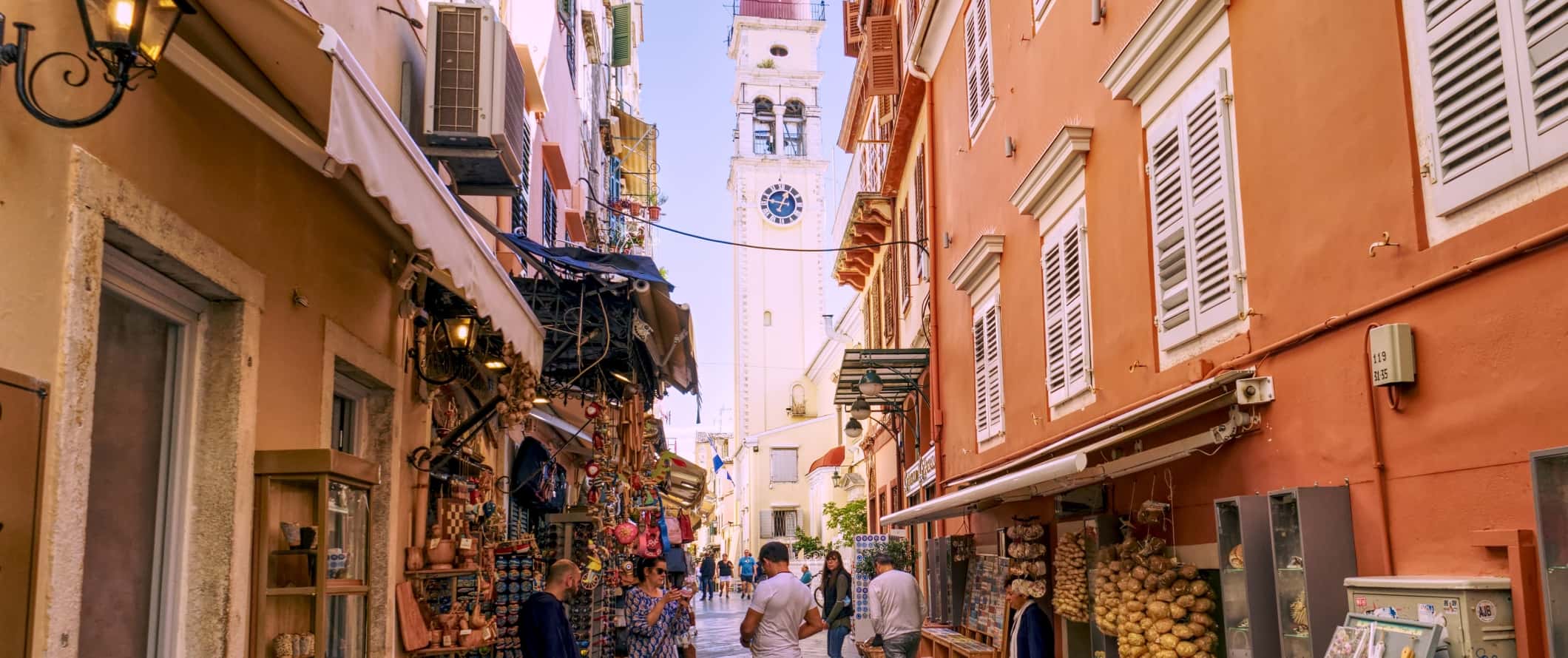 Vista da torre sineira no final de animadas ruas estreitas da cidade de Corfu, Grécia.< fan> Ferry Hopper - Se você deseja reservar ingressos a vapor, este site ajudará você a encontrar várias empresas, a fazer uma rota e reservar ingressos.