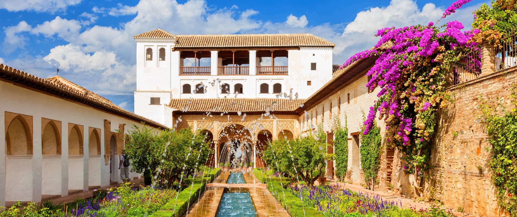 O famoso palácio de Algambra em granada, Espanha, com uma fonte longa e ervas exuberantes