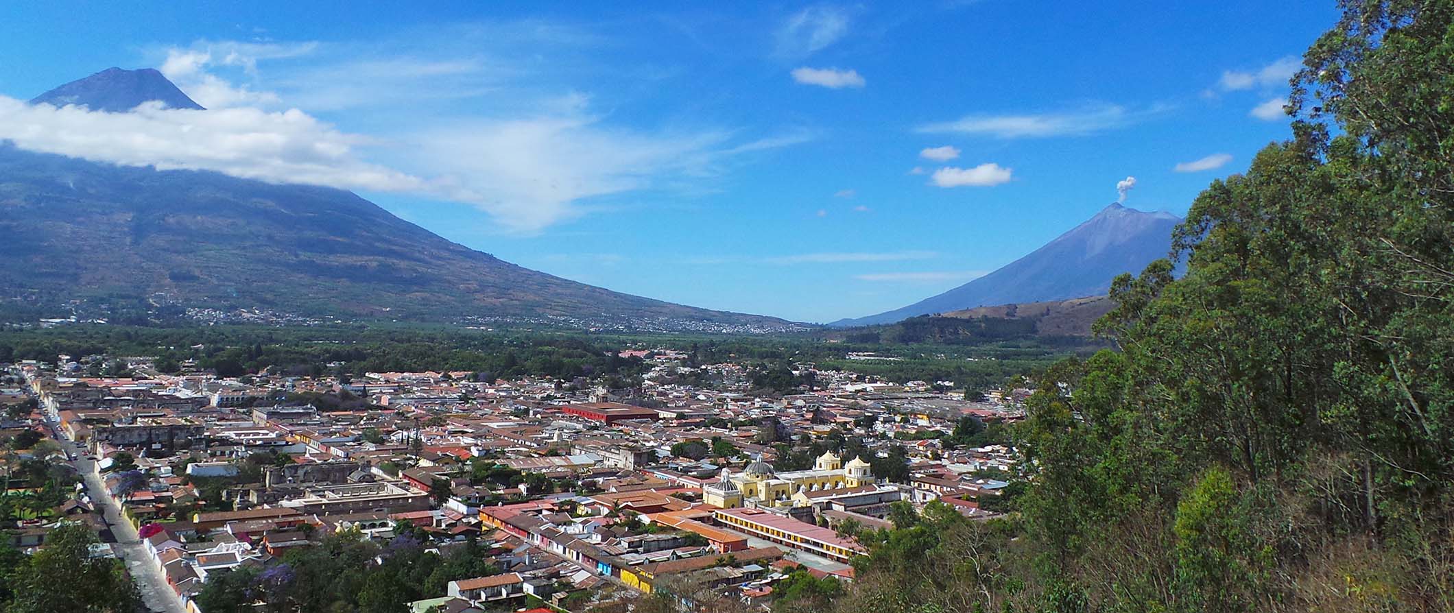 Vista de um vulcão na Guatemala com uma pequena cidade localizada num vale entre as montanhas