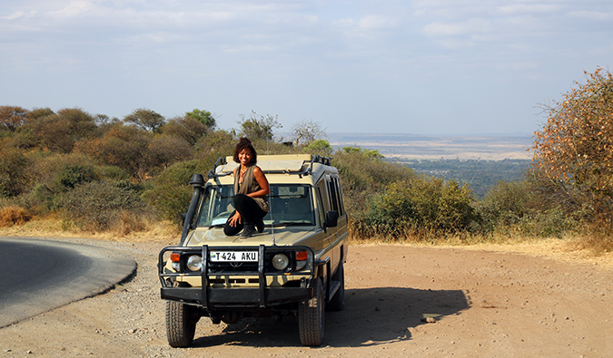 Heather, um viajante solitário, posa em seu jipe ​​de combustível na África