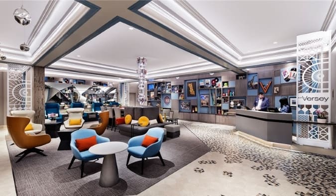 O espaçoso lobby do Versey Hotel apresenta cadeiras coloridas de design contemporâneo e arte nas paredes