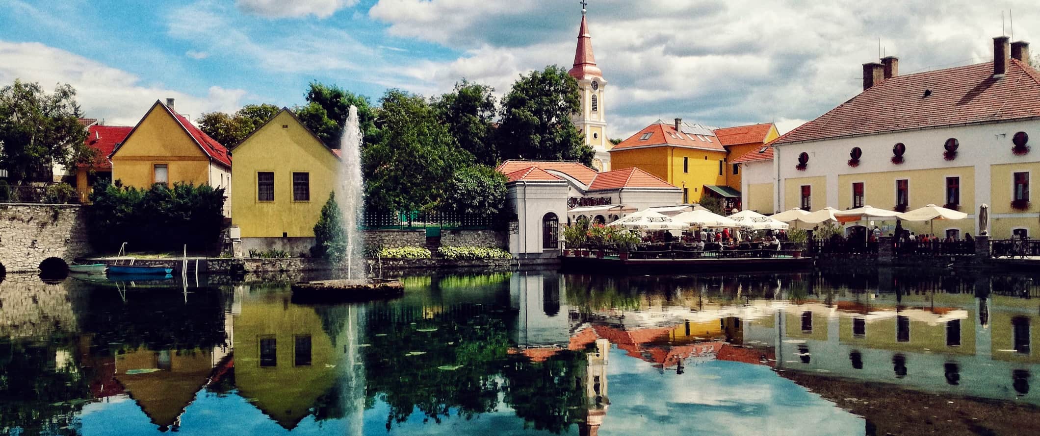 Cidade colorida e histórica na Hungria com uma reflexão em águas calmas