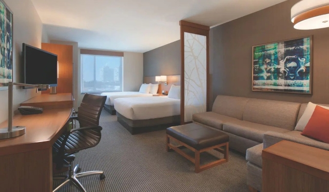 Quarto Hyatt Place Chicago South com 2 camas queen-size, mesa e sofá grande