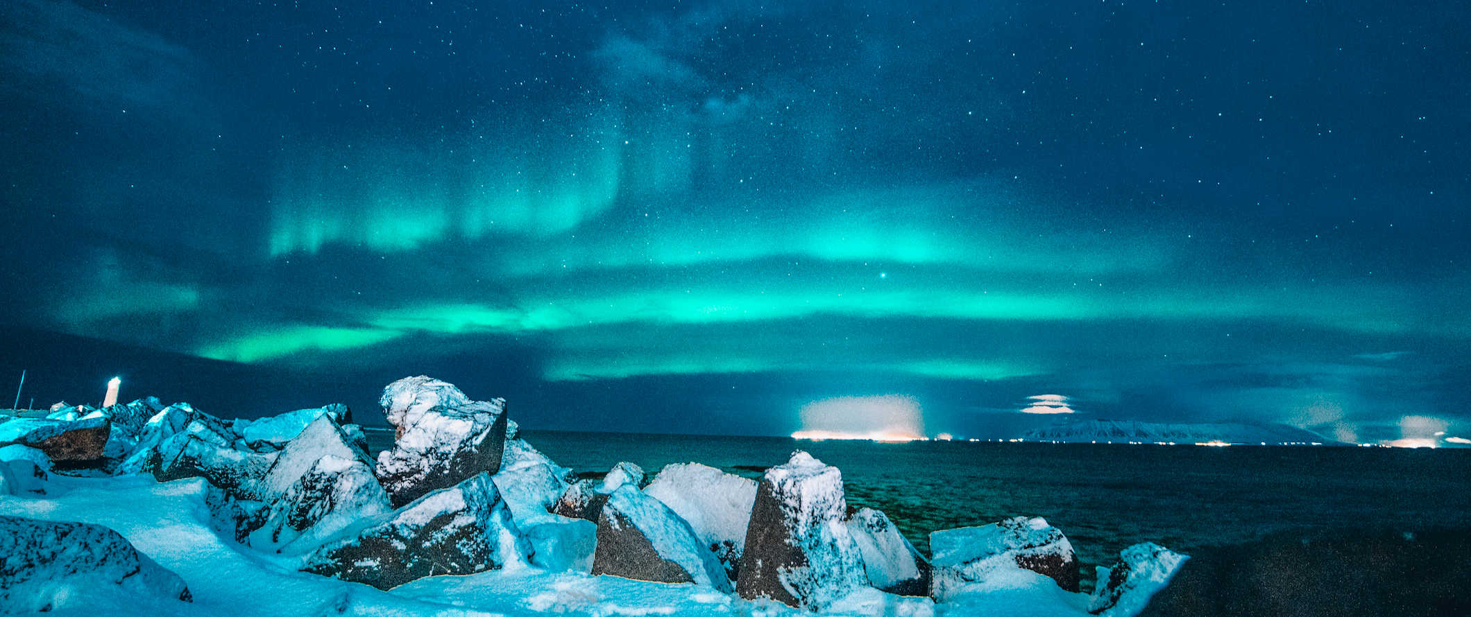 Luzes do norte verdes brilhantes sobre a paisagem nevada da Islândia