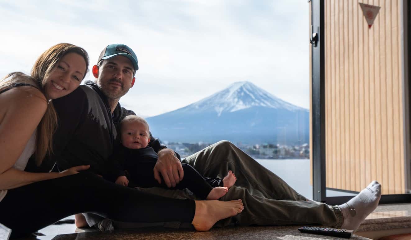 A blogueira Christine Addis, da Beael Muse, com seu parceiro e criança, sent a-se à janela no Japão no cenário de uma montanha nevada