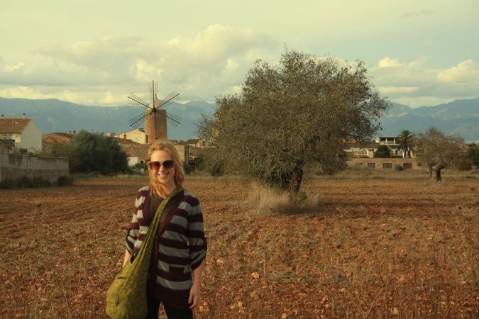 Jessica, uma viajante, posa para uma foto em um campo na Europa