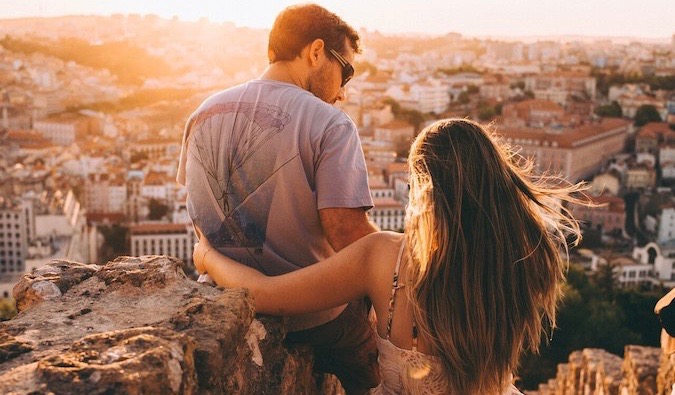 O casal olha para o pôr do sol, admirando a vista da cidade na Europa