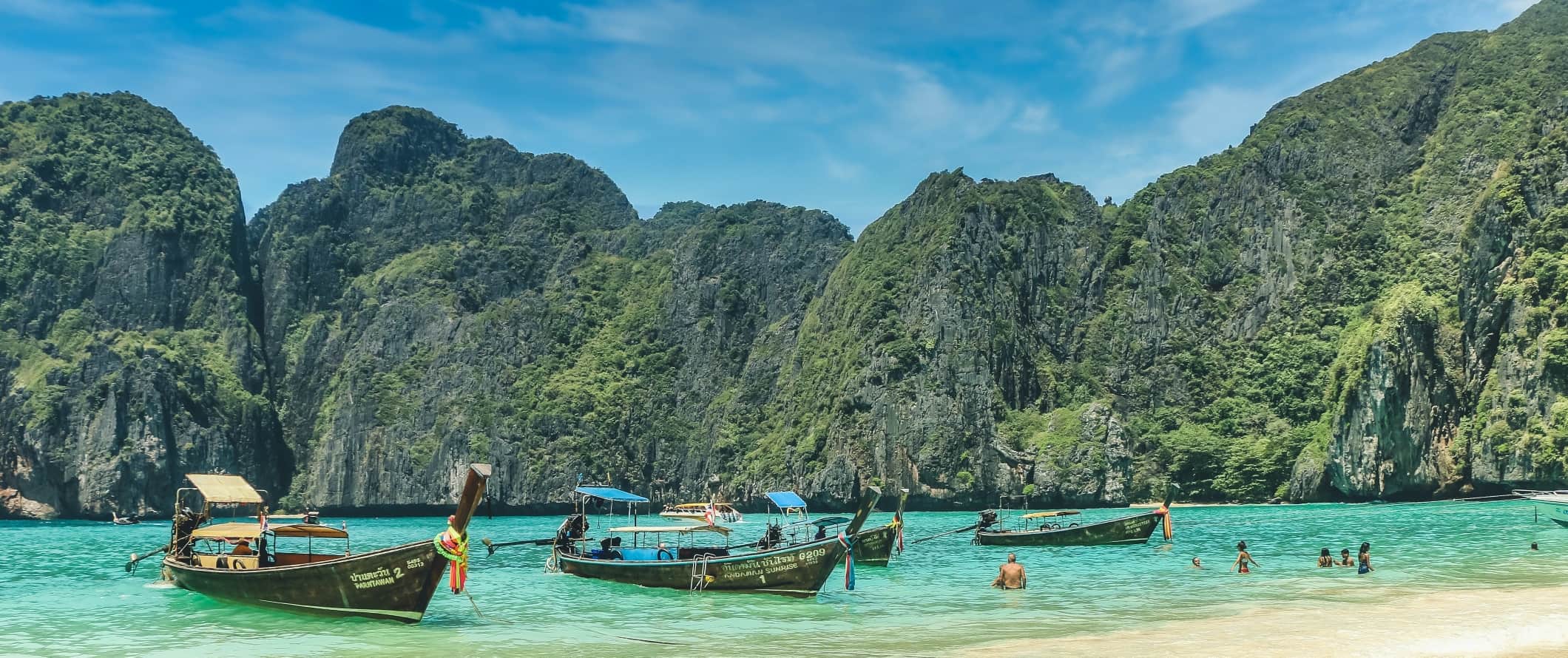 Barcos de alongamentos longos na praia na ilha de Ko Pih Pih, Tailândia