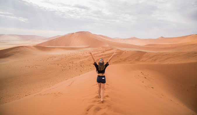 Christine Addis caminha pelas dunas de areia no deserto