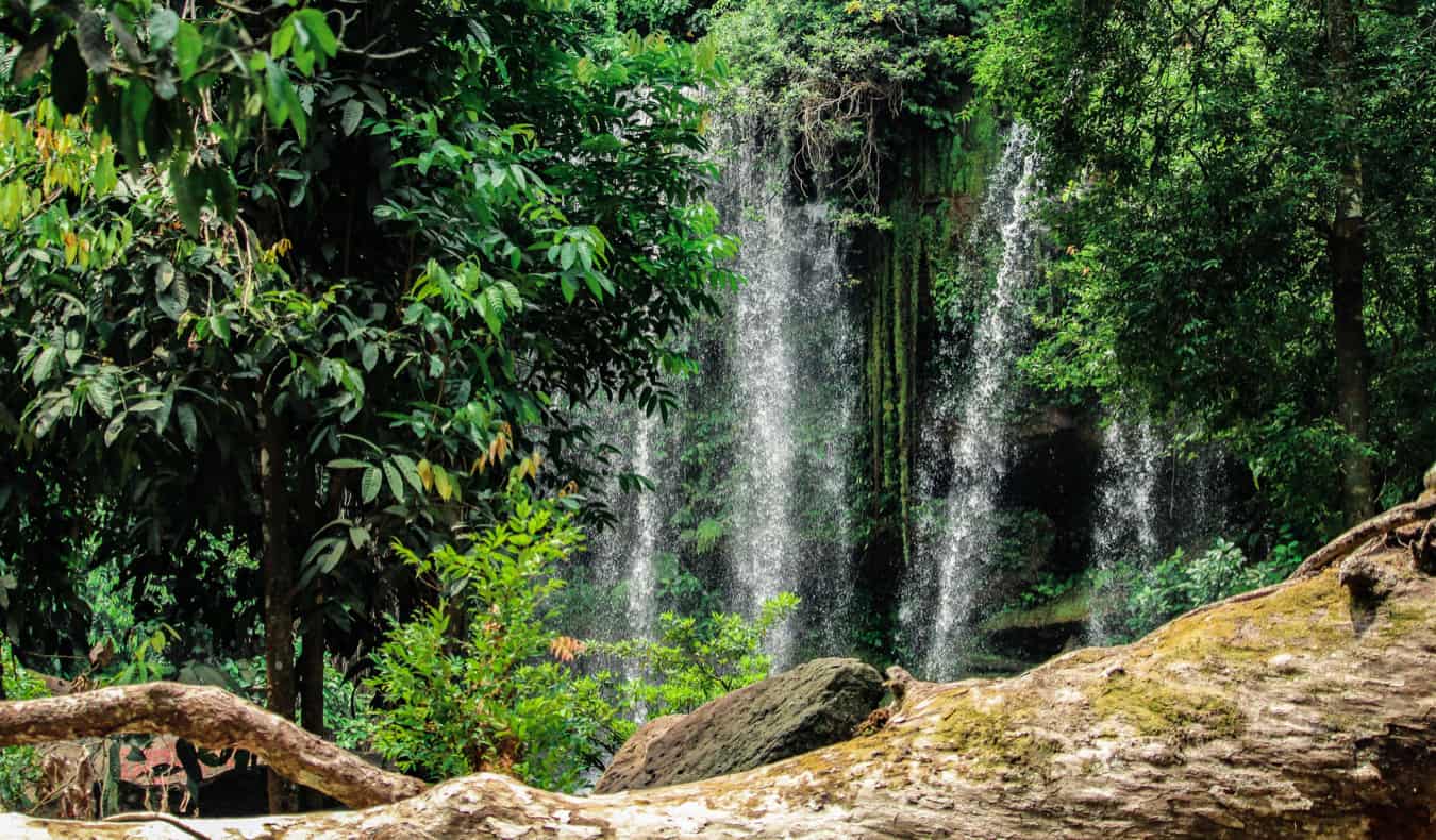 Cachoeira alta no meio da magnífica selva em um pône i-Camboja, Camboja