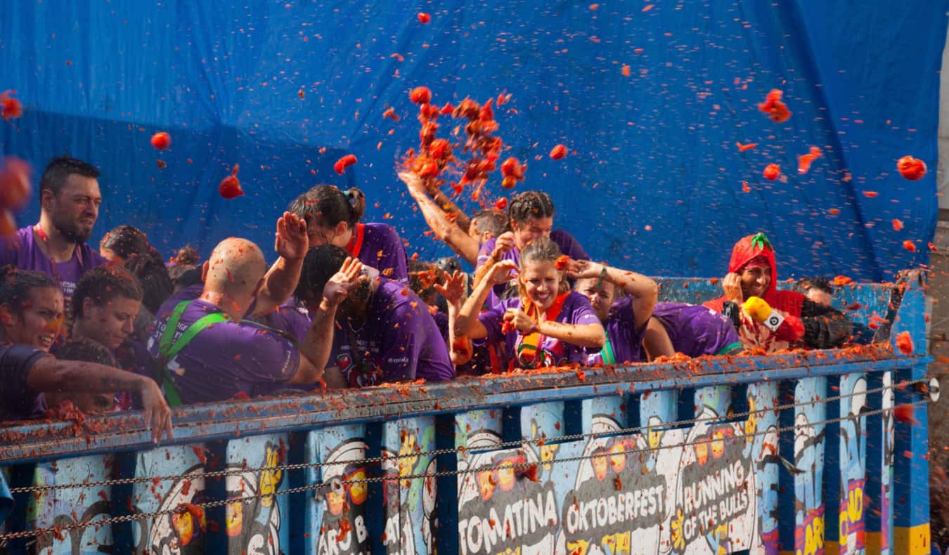 Uma multidão de pessoas cobertas com tomates vermelhos durante o festival La Tomatina na Espanha