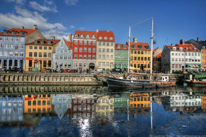 Uma fotografia de casas refletidas no porto de Schuhavn em Copenhague, Dinamarca