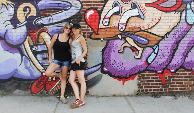 O casal encostado na parede com arte de rua