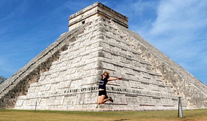 Uma mulher que visitou Chichens-iza, México, pula no ar para tirar uma foto
