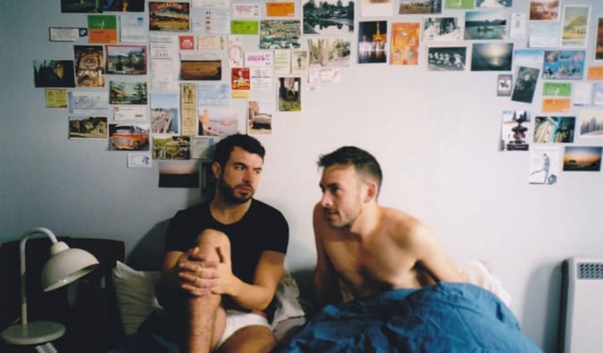 Dois homens sentados na cama