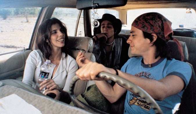 Três amigos fumando em um carro