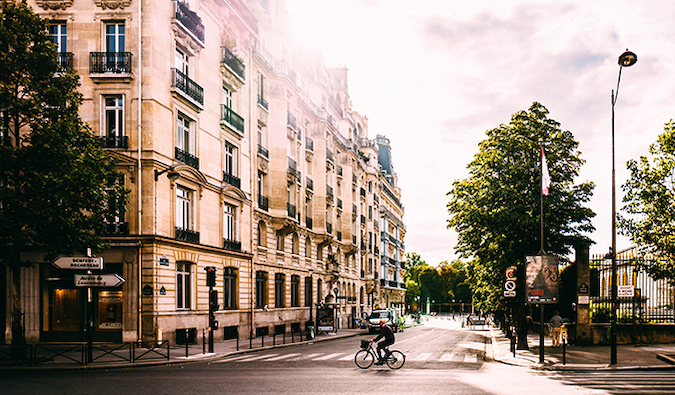 Um homem anda de bicicleta por uma encruzilhada nas ruas de Paris
