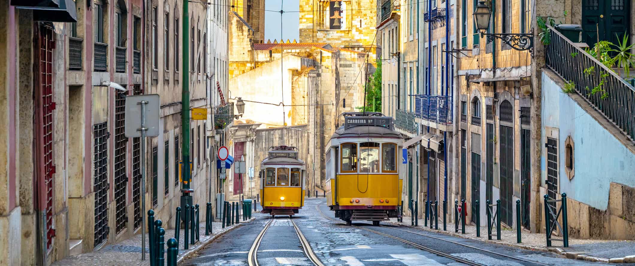 Velhos carros de rua amarela em uma rua estreita na colorida cidade de Lisboa, Portugal