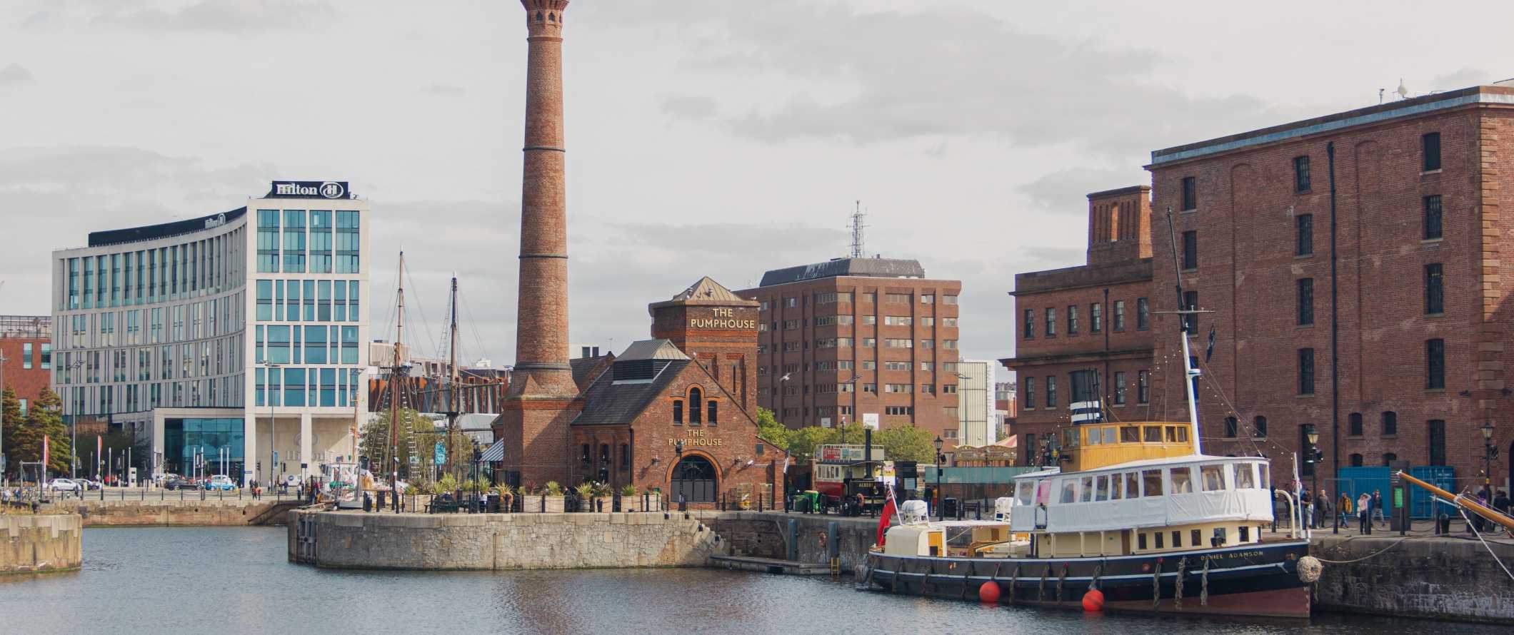 Navio histórico, armazéns e uma torre de água no Dock Royal Albert em Liverpool, Inglaterra