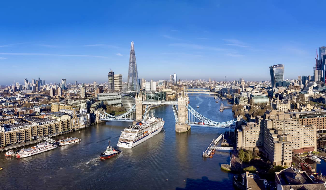 O icônico horizonte de Londres acima do Tamisa com barcos flutuando no rio