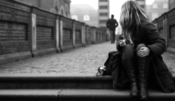 Fotografia em preto e branco de um viajante solitário de mulher sentado na escada.