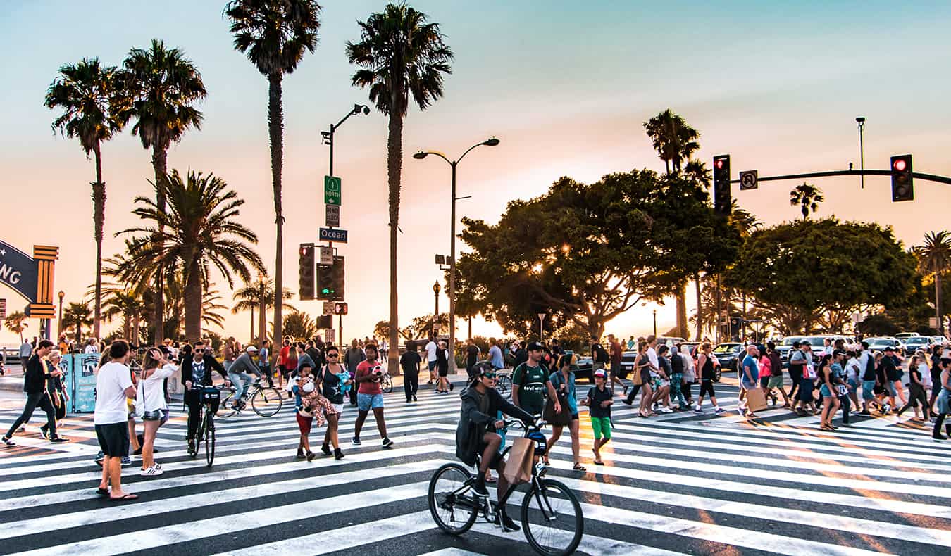 Uma faixa de pedestres movimentada em Los Angeles cheia de pessoas durante o pôr do sol
