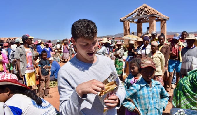 Nomad Matt come comida de rua em um mercado movimentado em Madagascar