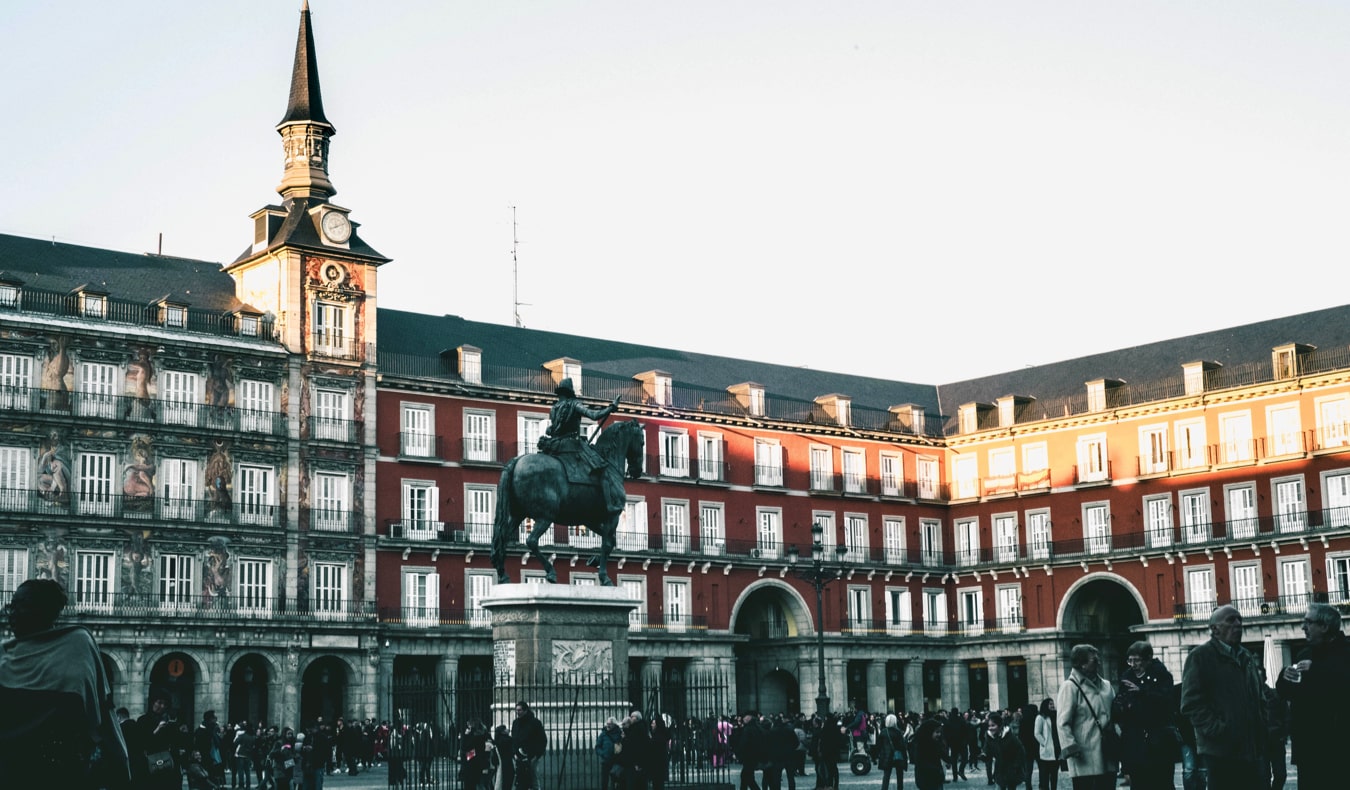 Os viajantes inspecionam a praça histórica em Madri, Espanha