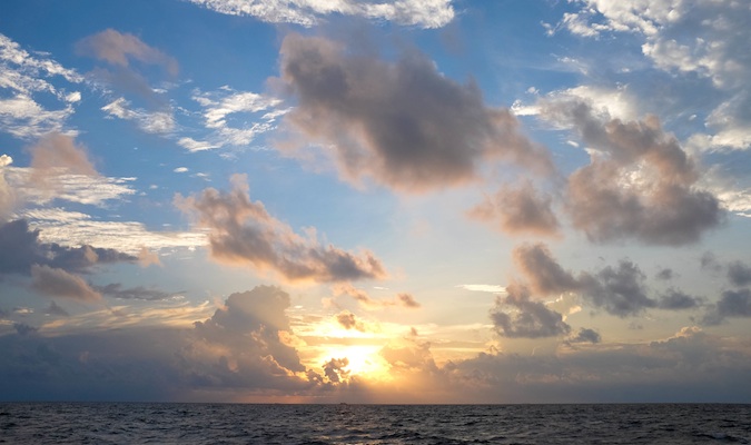 pôr do sol nublado sobre a água nas Maldivas
