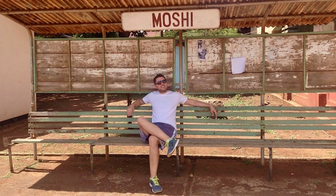 Mark Manson fica em um ponto de ônibus em Moshi, Tanzânia
