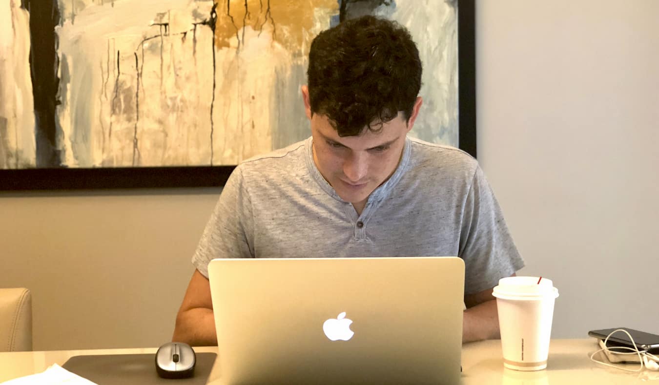 Matt Kepnes, da Nomadic Matt, trabalha em um laptop à mesa