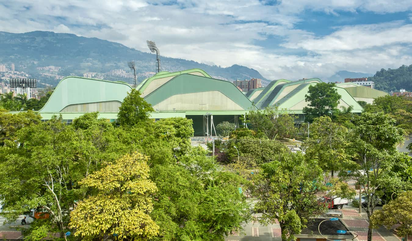 Um enorme estádio de futebol em Medelin, Colômbia, cercado por vegetação