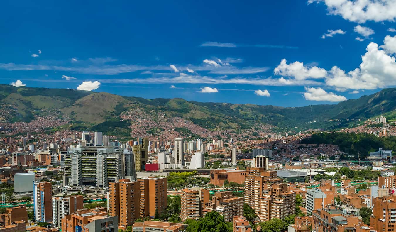 Skyline da colorida Medellín, Colômbia, cercada por vegetação em um dia ensolarado
