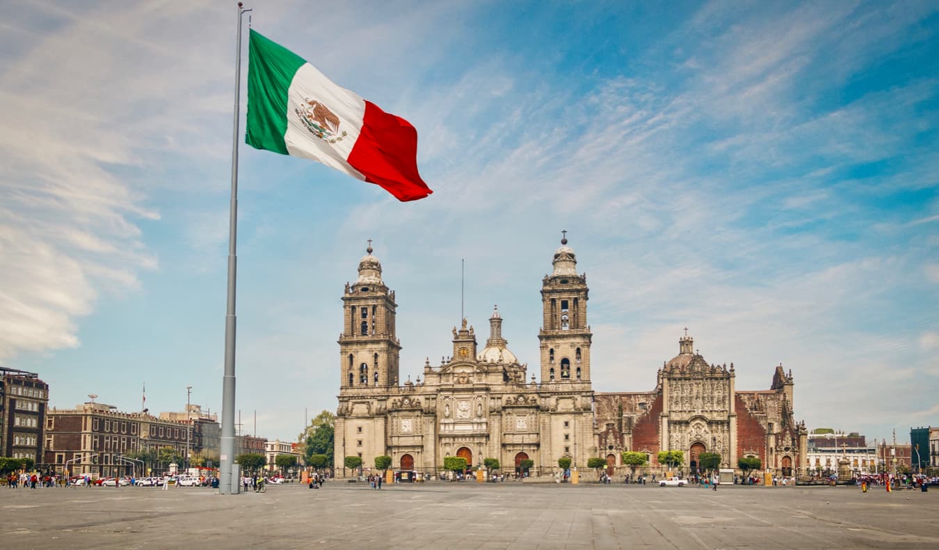 Uma grande bandeira mexicana em frente a um dos muitos edifícios históricos da Cidade do México, México