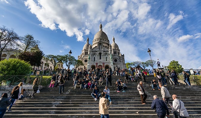 A famosa escada de um Sacre-Cur, cheia de pessoas, em Montmartre, Paris